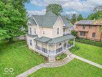 Charming two-story home featuring a classic wrap-around porch and lush green lawn at 4526 Iowa St, Clayton, IN 46118
