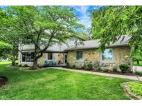Charming stone home with lush landscaping, a well-manicured lawn, and a welcoming front entrance at 4990 E County Road 750 S, Brownsburg, IN 46112