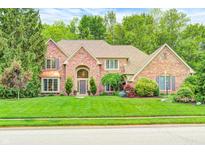 Charming brick home featuring a manicured lawn and mature trees, perfect for curb appeal at 5404 Cayman Dr, Carmel, IN 46033