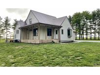 Charming two-story home featuring a metal roof, inviting porch, and a well-manicured front yard at 6593 N 800 W, Elwood, IN 46036