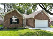 Charming brick home featuring an attached two car garage, well manicured lawn, and attractive landscaping at 6845 Arjay Dr, Indianapolis, IN 46217