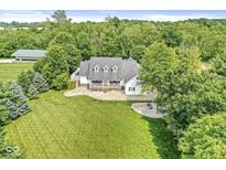 Aerial view showcases the home with manicured lawn, mature trees, and inviting outdoor space at 7221 State Road 42, Martinsville, IN 46151
