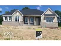 Charming one-story home featuring stone accents, a covered porch, and stylish architectural details at 9437 Dogwood Dr, McCordsville, IN 46055