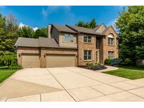 Charming brick two-story home featuring a spacious driveway, attached two-car garage, and meticulously manicured lawn at 9804 Wentworth Ct, Carmel, IN 46032