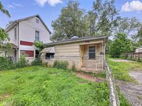 Exterior view of a detached house and overgrown lawn in need of significant repair at 1140 Mcdougal St, Indianapolis, IN 46203