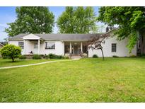 Charming single-story home with a well-manicured lawn and inviting walkway at 1212 Woodlawn Ave, Indianapolis, IN 46203
