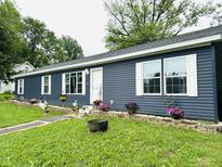 Charming single-story home showcasing blue siding, white trim, and a well-manicured lawn at 125 W Church St, Thorntown, IN 46071