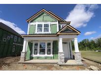 New home in progress with white trim, stone accents, and a covered front porch, showcasing modern design and curb appeal at 1813 Real St, Indianapolis, IN 46240