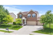 Two-story brick home with a well-manicured lawn and attached two-car garage under a blue sky at 1821 Midnight Pass, Brownsburg, IN 46112