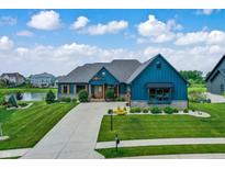 Beautiful home featuring a manicured lawn, elegant entry, and a spacious driveway leading to a three-car garage at 18398 Cross Lakes Ct, Westfield, IN 46074