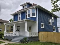 Two-story home features a white-columned front porch and blue siding at 24 N Randolph St, Indianapolis, IN 46201