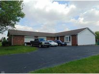 View of the exterior showing the brick and siding, driveway and multiple cars parked at 2625 S 200 E, Lebanon, IN 46052