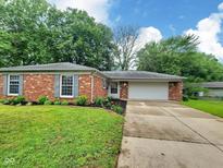 Charming brick home with manicured lawn, complemented by an attached two car garage at 2741 Fairlawn Dr, Columbus, IN 47203