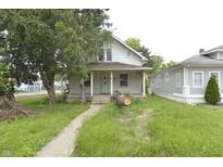 Quaint two-story home featuring a covered front porch and a mature tree in the front yard at 364 S Cole St, Indianapolis, IN 46241