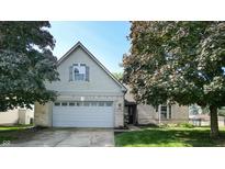 Charming two-story home with brick accents, a two-car garage, and a well-maintained front yard with mature trees at 3959 Towhees Dr, Indianapolis, IN 46237