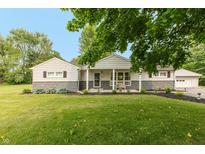 Charming single-story home with stone accents, covered porch, and well-manicured front lawn and a detached garage at 4195 Locust Ln, Brownsburg, IN 46112