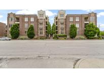 Charming brick condo building with balconies, mature trees, and manicured landscaping at 450 E Ohio St # Apt 305, Indianapolis, IN 46204