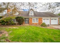 Charming brick home featuring a well-maintained lawn, mature trees, and an attached two-car garage at 5939 Olivia Dr, Alexandria, IN 46001