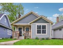 Charming bungalow featuring craftsman architecture, a covered front porch, and a well-maintained lawn at 617 N Dearborn St, Indianapolis, IN 46201