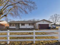 Charming single-story home with white siding, a two-car garage, and a well-maintained front yard at 619 Belzer Dr, Anderson, IN 46011