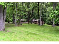 Secluded brick home exterior nestled among mature trees and lush green lawn at 6190 Red Day Rd, Martinsville, IN 46151