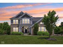 Charming two-story home featuring brick and siding with a well-manicured lawn and colorful sunset at 644 Ridge Gate Dr, Brownsburg, IN 46112