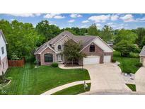 Charming brick and stone two-story home with a well-manicured lawn and three-car garage at 8338 Hunters Meadow Way, Indianapolis, IN 46259