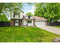 Charming two-story home with a brick and siding exterior, lush green lawn, and attached two car garage at 8416 Buckingham Dr, Columbus, IN 47201