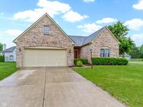 Charming brick home with a two-car garage and well-manicured lawn in a suburban neighborhood at 8599 Lansdowne Dr, Fishers, IN 46038