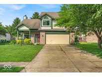 Charming two-story home with a well-manicured lawn and attached two car garage at 8908 Sunningdale Blvd, Indianapolis, IN 46234