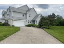 Inviting two-story home with a two car garage, neutral siding, manicured lawn, and mature trees at 11621 Coastal Dr, Indianapolis, IN 46229