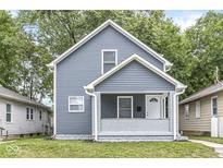 Charming blue two-story home with a cozy front porch and well-maintained lawn at 1425 N Grant Ave, Indianapolis, IN 46201