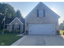 Charming brick home with a two-car garage, well-manicured lawn and patriotic American flag at 2018 Alysheba Dr, Indianapolis, IN 46234