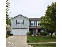 Charming two-story home with well-manicured lawn, attached garage and an inviting front porch with an American flag at 2210 Bridlewood Dr, Franklin, IN 46131