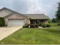 Well-maintained brick home featuring an attached garage and a beautifully landscaped front yard at 2916 Wind Chime Cir, Greenwood, IN 46143