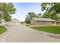 Charming brick home with a gravel driveway and a large outbuilding, perfect for a workshop or storage at 312 W Clark Ln, Fairland, IN 46126