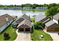 Aerial view of brick home with an attached two car garage and waterfront views at 3404 Maritime Dr, Indianapolis, IN 46214
