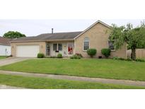 Charming brick home with a well-maintained lawn, attached garage and a red front door at 3645 Richland Dr, Columbus, IN 47203