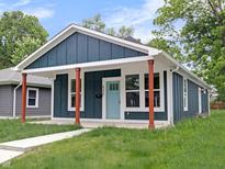 Charming home with a blue exterior, inviting porch, and well-manicured lawn at 4230 Kingsley Dr, Indianapolis, IN 46205