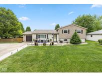Charming home with a well-manicured lawn, a stone walkway and a cozy front porch seating area at 580 Northgate Dr, Greenwood, IN 46143
