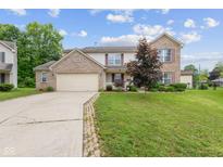 Charming two-story brick home featuring an attached two car garage and a well manicured front yard at 5852 Long Ridge Pl, Indianapolis, IN 46221