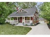 Charming home featuring a classic red exterior, inviting front porch, and well-maintained landscaping at 625 E 57Th St, Indianapolis, IN 46220