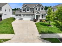 Charming two-story home with a three-car garage, manicured lawn, beautiful landscaping, and attractive curb appeal at 6830 Park Grove Blvd, Whitestown, IN 46075