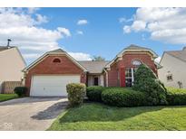 Charming brick home featuring a two-car garage, landscaped yard, and eye-catching architectural details at 69 Stoneybrook Dr, Greenwood, IN 46142