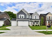 Inviting two-story home featuring a spacious three car garage and beautifully maintained front yard at 7147 Buckley Branch Dr, Indianapolis, IN 46259