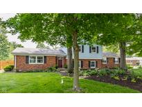Charming two-story home featuring a blend of brick and siding, complemented by mature trees and lush landscaping at 7935 N County Road 650 E, Brownsburg, IN 46112