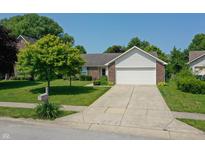 Charming single-story home featuring a two-car garage, well-maintained lawn, and mature shade trees at 7942 Dillon Pl, Indianapolis, IN 46236