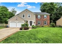 Charming two-story home featuring a blend of brick and siding, a well-manicured lawn, and an attached two-car garage at 9302 Budd Run Dr, Indianapolis, IN 46250