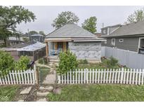 Exterior view of a home with a white picket fence and a partially renovated front facade at 952 Lasalle St, Indianapolis, IN 46201