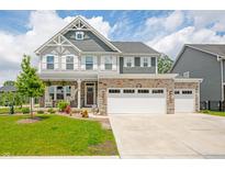 Charming two-story home featuring stone accents, a welcoming porch, and a three-car attached garage at 1026 Woodglen Dr, Westfield, IN 46074